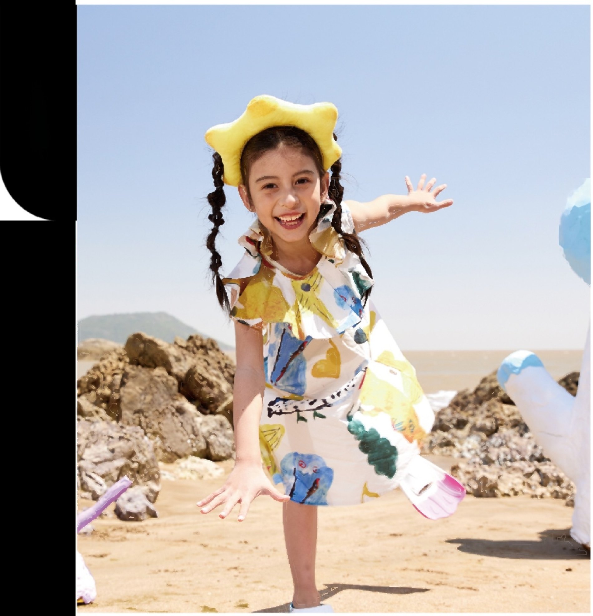 A child in a hand-painted DC Kids summer dress laughing on the beach