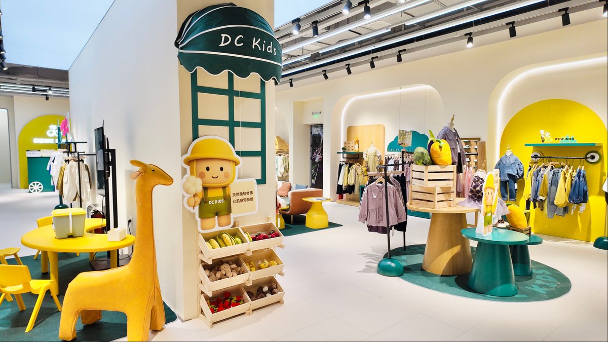 DC Kids store interior — mascot, giraffe and natural-fabric market displays